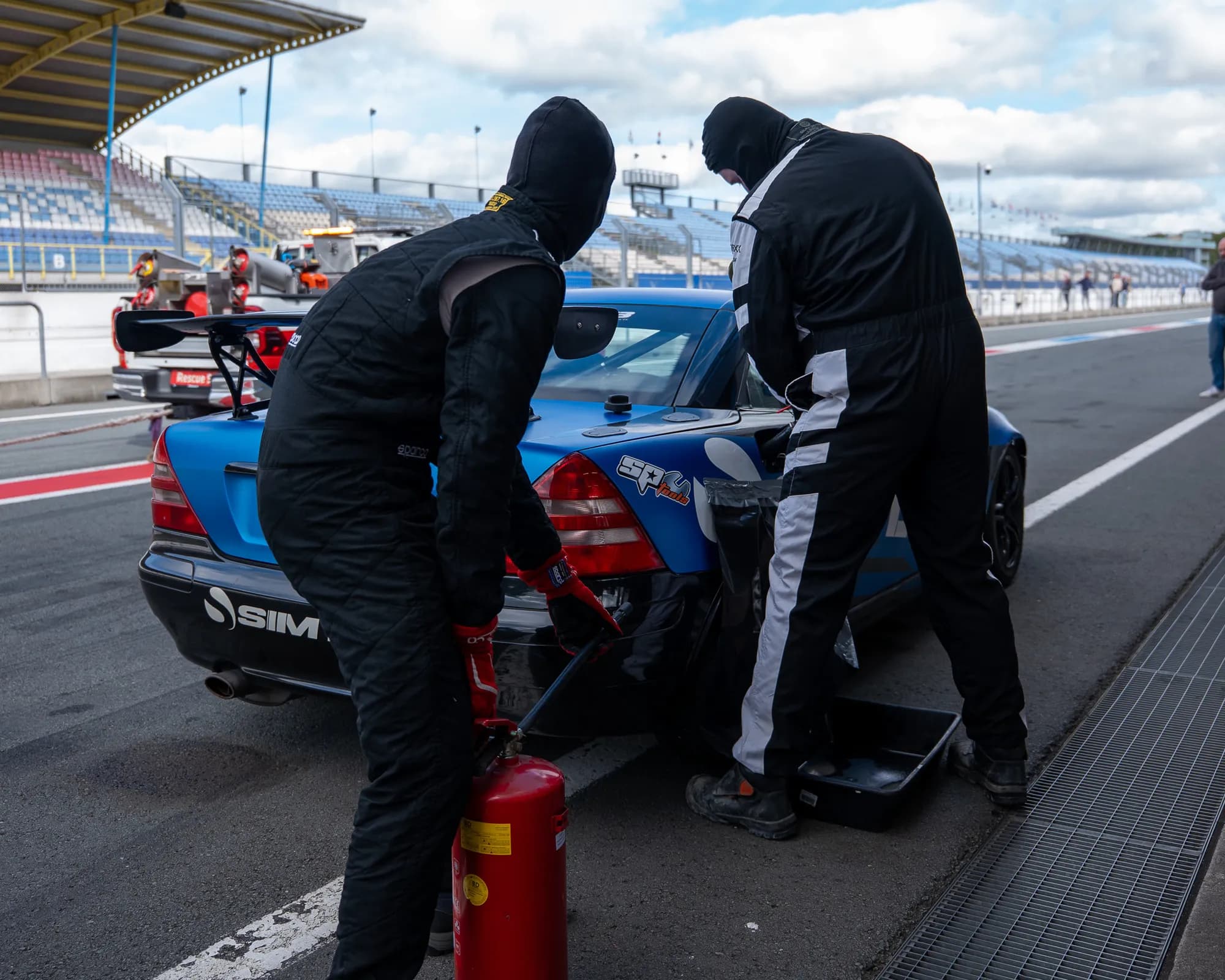 De crew aan het werk aan de Sim-Lab SLK tijdens een pitstop